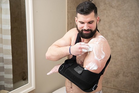 man with arm brace cleaning